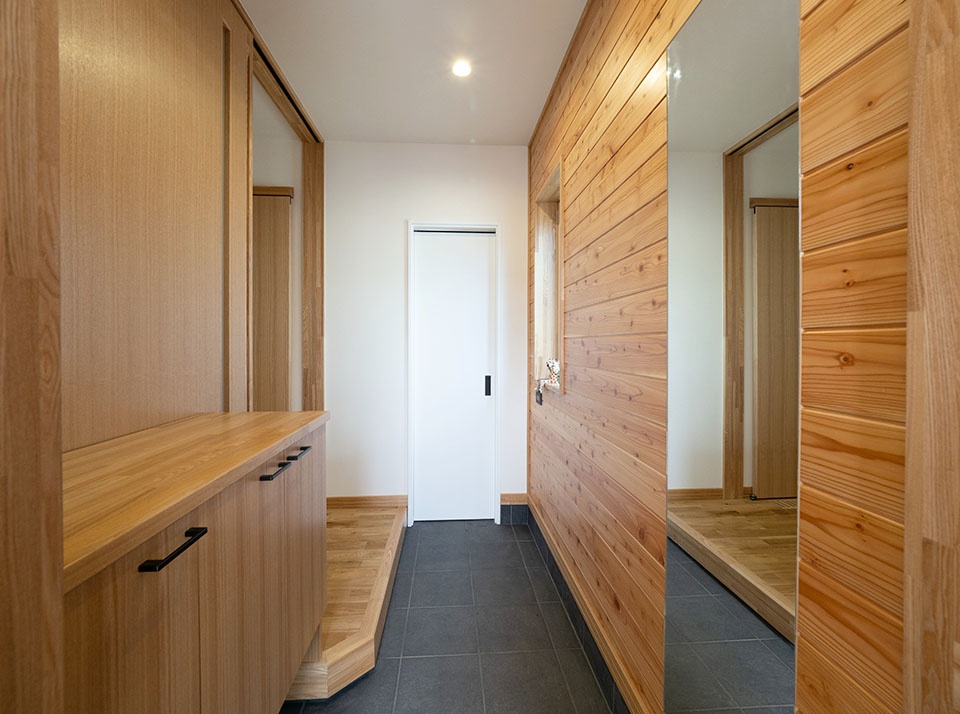 玄関の壁は、カラマツ羽目板張り