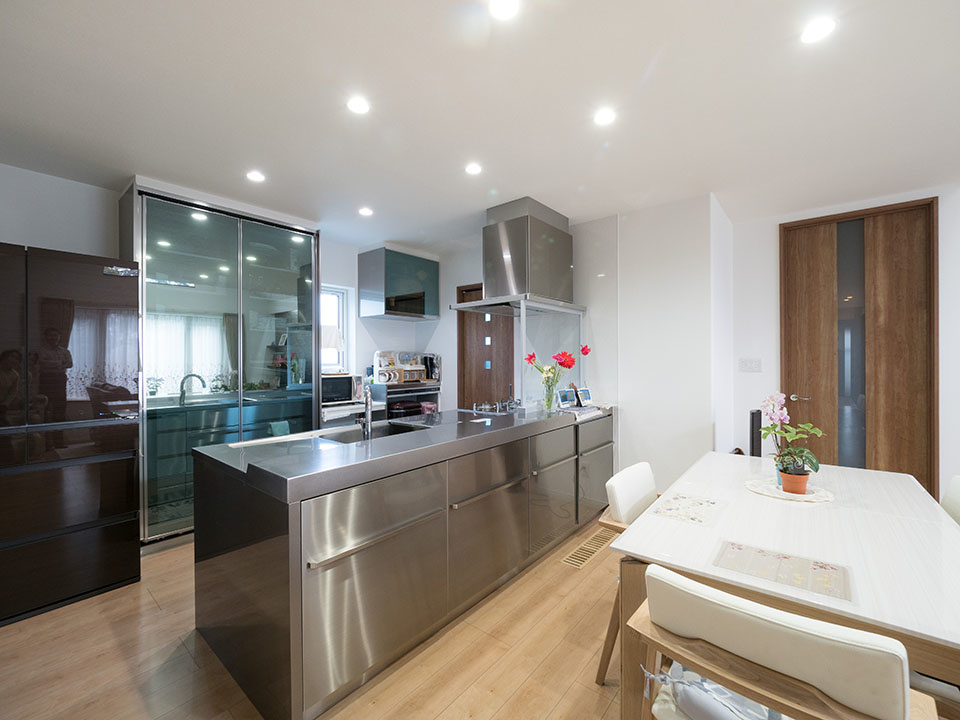 存在感のあるステンレス製キッチン、おしゃれなガラス戸のキッチン収納