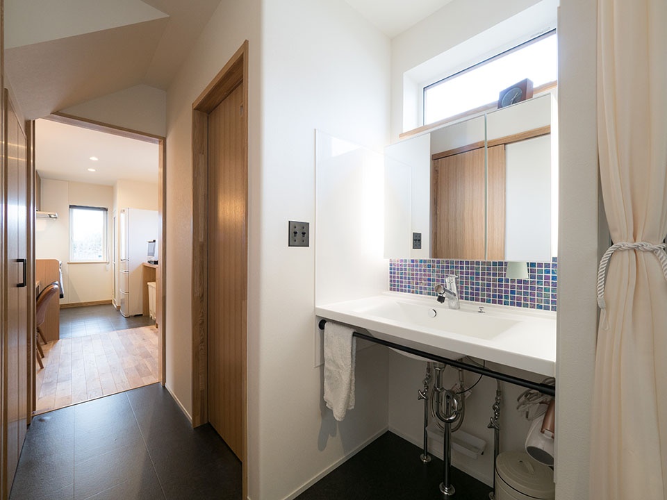 サンワカンパニーの鏡やカクダイのボウル、名古屋モザイクのタイルを使って造作した洗面化粧台