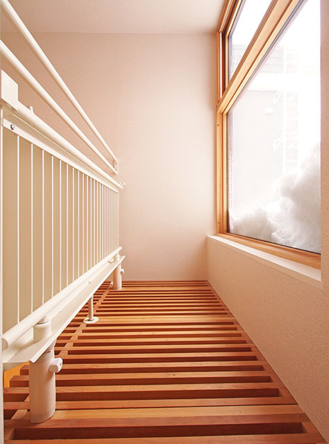 吹き抜けにつながる扉を開けると、キャットウォークになっており、手すり代わりに放熱パネル（左の白いもの）がある。暖房だけでなく、冷房でも使えるのは、地中熱ヒートポンプだから