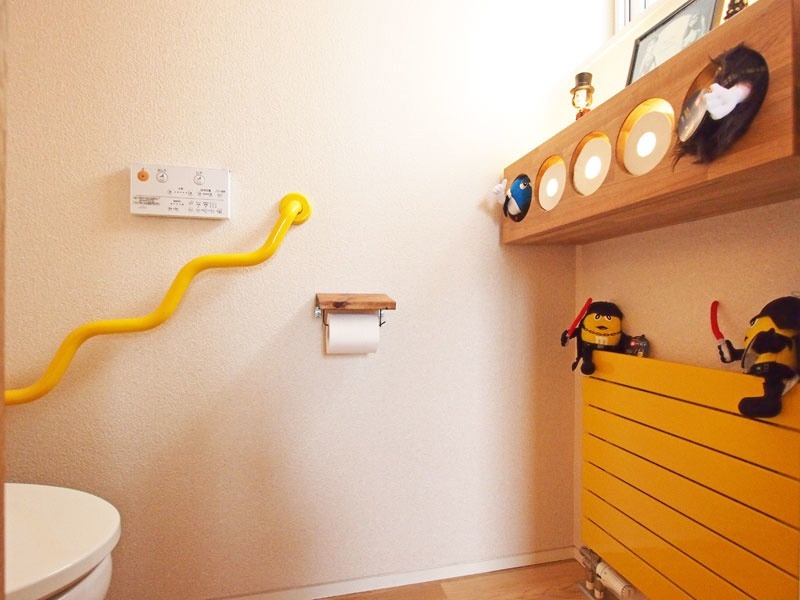 Ｓさんの要望で、トイレットペーパーを収納する棚を楽しい仕掛けにした（写真右上）。左の黄色い手すりは奇抜だが、実は実用性を考えたデザイン