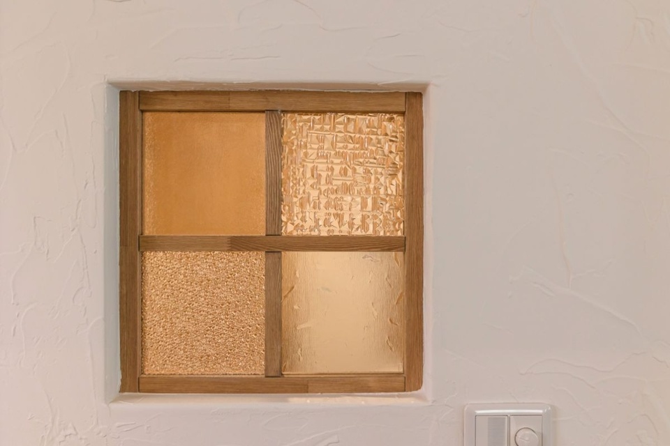 乾燥室の窓。ガラスは数種ある候補の中からご夫婦で熟考して組み合わせました。塗り壁はカントリーヴィレッジの事務所と同じ、ざらりとした風合いを感じさせる仕上がりに