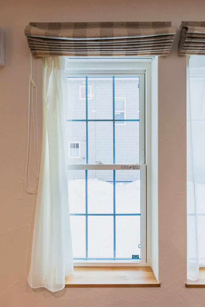 格子の入った欧米風のデザインが気に入って選んだ窓はクレトイシ株式会社の「モンタージュ」というシリーズのもの。北側・東側には日射遮蔽タイプを、南側・西側には日射取得タイプを使っています