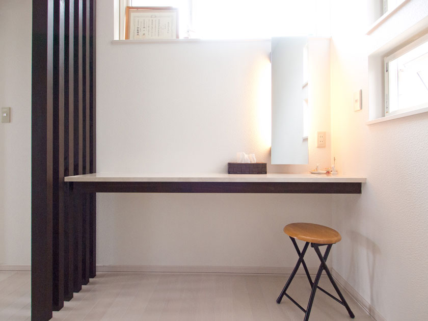 寝室の化粧台。生活感が滲み出ないよう収納のないデザインに。鏡の後ろは間接照明