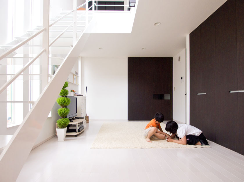 正面の幅1間もある超ワイドな引き戸の向こうが玄関。右の収納ドアは天井までの高さにしたことで見事に調和している