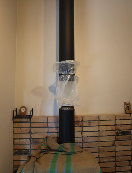 煙突掃除はこのようにビニールをつけて、上から煤をこそげおとす。ストーブに落としてしまってもいいそうだが、今回はこのやり方で。