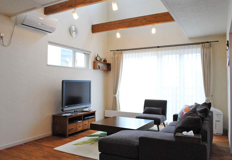 リビングは上質なナラ材の床と、上部の吹き抜けに2本の梁を見せることで木の存在感を醸し出している