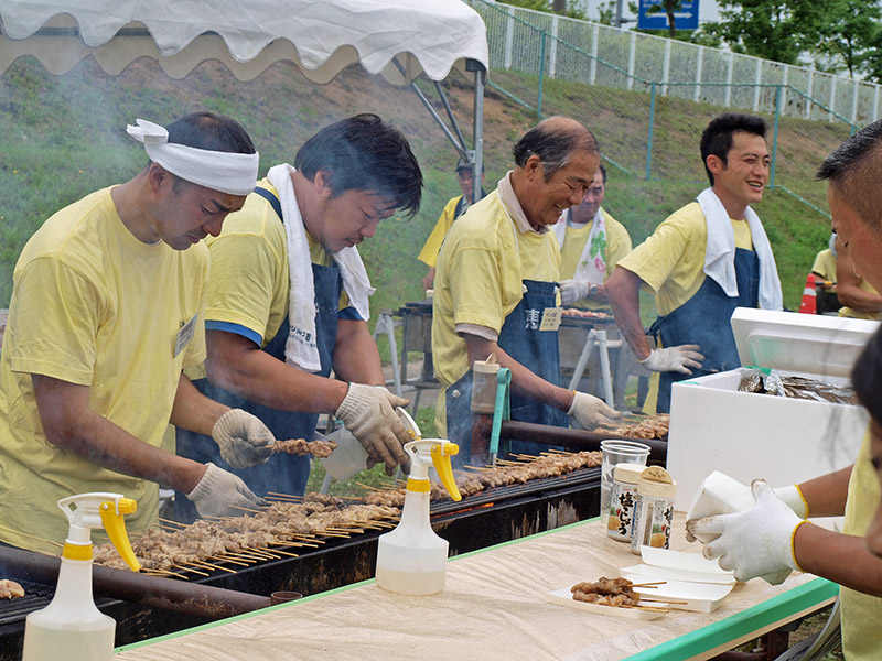 焼き鳥を焼くキクザワ恵風会のみなさん。「できたてだよ!」と威勢よい声