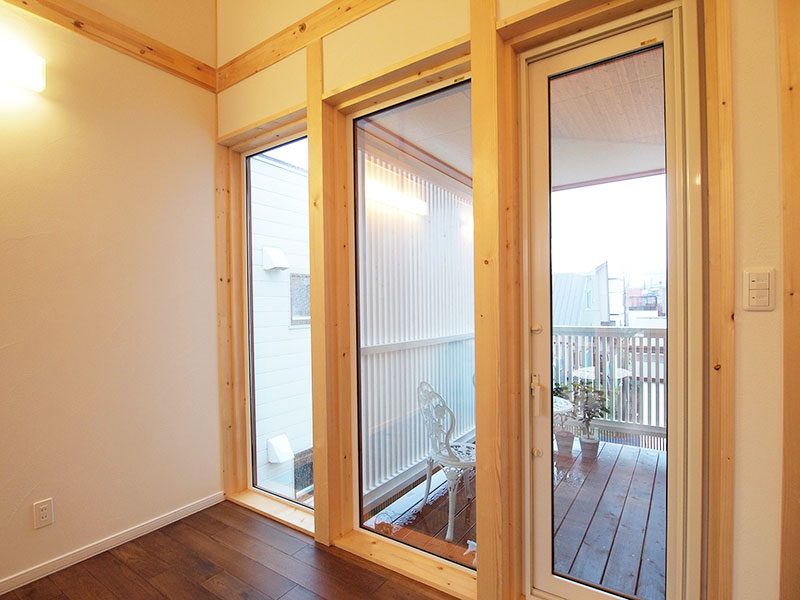 ダイニングからウッドバルコニーに直接出られる。隣にアパートがあるため、目隠し用にフェンスを設置