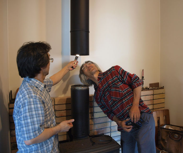 「おおーっ、煤がついていますねー」煙突をのぞく中村さん。