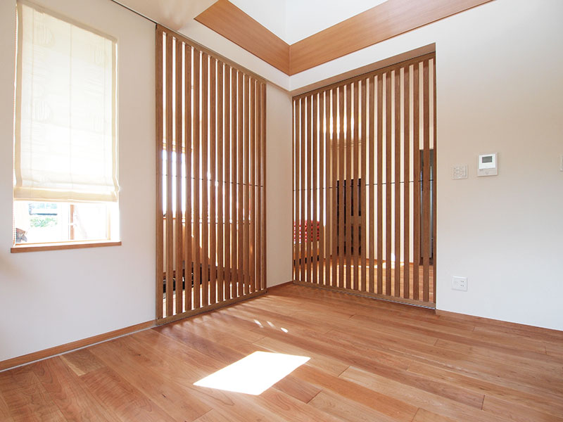 玄関ホールとリビング、寝室とリビングはそれぞれ縦格子の引戸で仕切ることができる