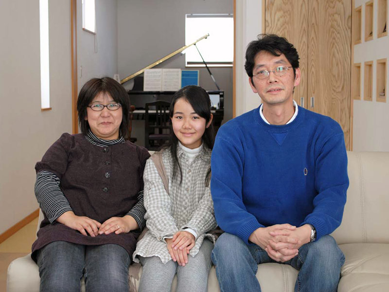 「白田さんのおかげで希望通りの家になりました」と微笑むIさんご夫妻と娘さん。リビングから和室、ピアノの部屋と段差のないひと続きの空間になった