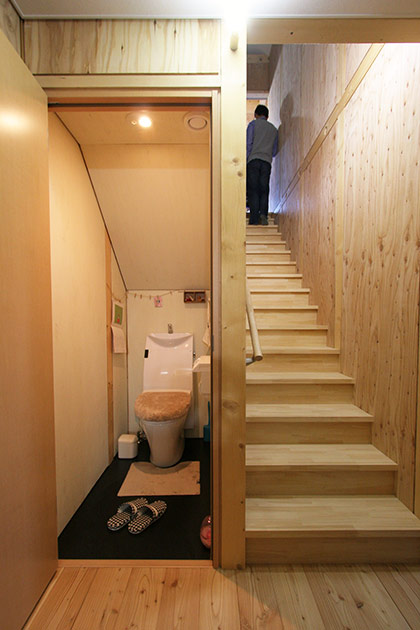 玄関ホールから2階にまっすぐ上がる階段は、親世帯用。左のトイレの天井が斜めなのは、そこに子世帯の階段が通っているから