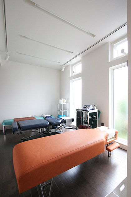 治療院の治療室。天井をより高く見せるため、蛍光灯は壁埋め込み式にした
