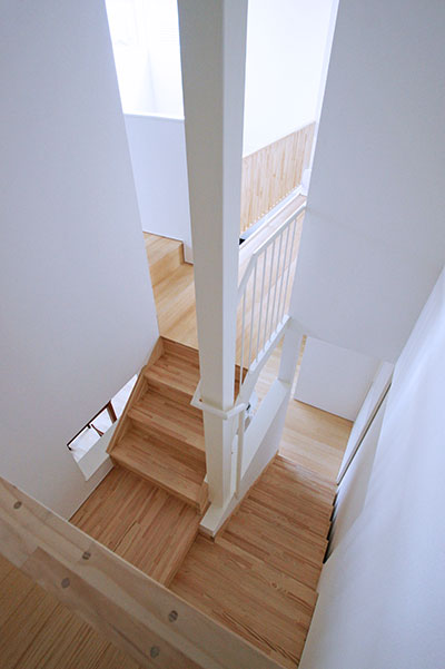 2階から階段を眺める。広い踊り場のようになっているのは、中2階収納庫の入口だ