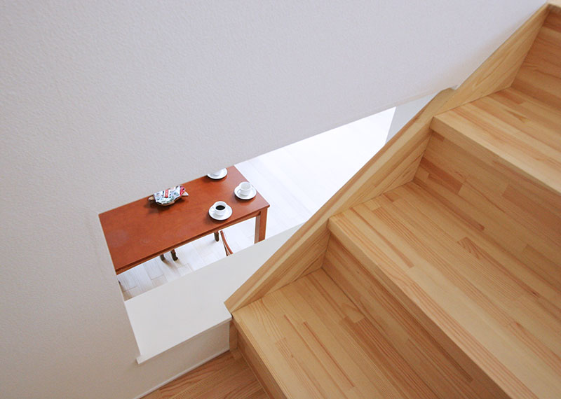 階段途中の壁を少しくり抜き、ダイニングの気配がわかるようにした