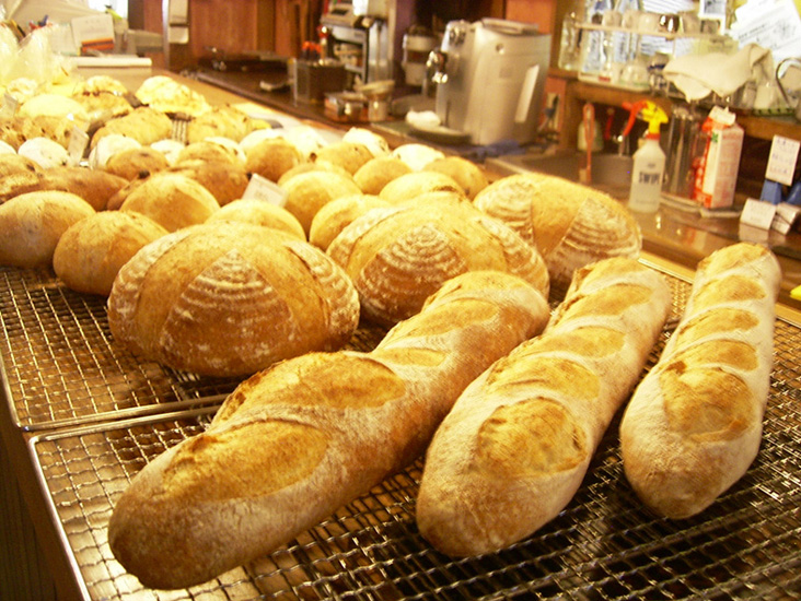 自家製酵母と石臼挽きの全粒粉を使用したバケット(360円)、田舎パン(小150円)、他にもレーズン入り(小150円大300円)、オリーブ入り(小150円)、メロンパン(150円)。天然酵母は月・水・金曜日に焼いている(オリーブ入りは金曜日のみ)